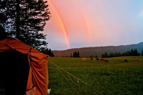 tent with rainbow in distance